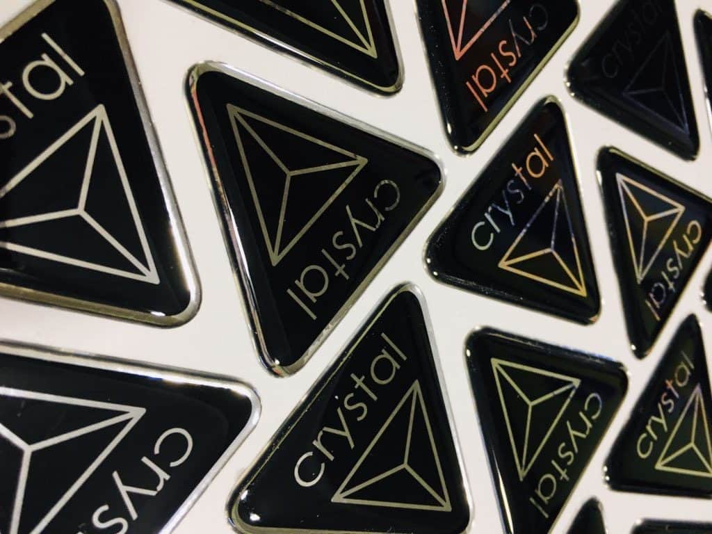 Чорні трикутні наклейки з логотипом "crystal" у золотистому кольорі