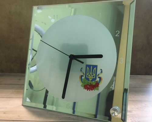 Годинник зі скляним корпусом та гербом України, чорні стрілки